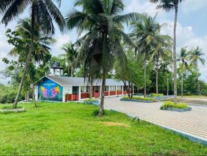 a building with a mural on the side of it at Swarna Green Valley Resort in Perdūru