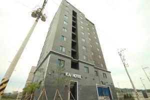 Un edificio alto y gris con un cartel. en Jinju Kai Hotel, en Jinju