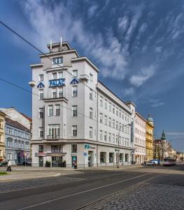 a white building with a blue sign on it on a street at Hotel Palác in Olomouc