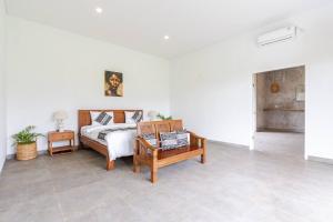 a white room with a bed and a table and a bed sidx sidx at Bali Eco Retreat in Bangli