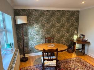 a dining room with a table and a lamp at The Garden House in Bishop Burton