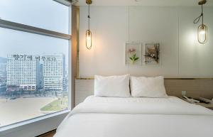 Postel nebo postele na pokoji v ubytování Gwangalli Hotel primavera in Busan