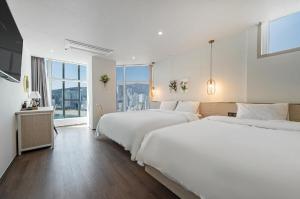 Postel nebo postele na pokoji v ubytování Gwangalli Hotel primavera in Busan