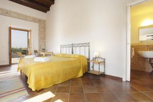 a bedroom with a bed with a yellow blanket at Casa al Castello in Cannizzara