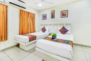 Giường trong phòng chung tại Fabhotel Colors Service Apartment - Nr MRC Nagar
