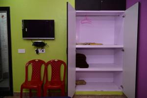 a closet with two red chairs and a tv at Roy Guest House in Kānki +21 photos