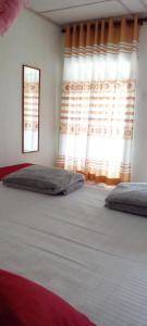 Un dormitorio con dos camas y una ventana. en Tree Cool Resort, en Ella