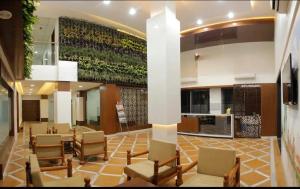 eine große Lobby mit Stühlen und einer großen Wand in der Unterkunft Hotel Raviraj, Chhatrapati Sambhaji Nagar in Aurangabad