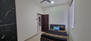 a room with a bed and a ceiling fan at Suria Aman Homestay Semi-D 5 Rooms 5 Bathrooms in Taiping