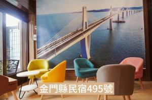 una stanza con sedie e un dipinto di un ponte di 馨悅民宿 a Jinning