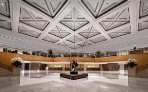 a lobby with a large ceiling with a statue in the middle at Jinling Hotel in Nanjing