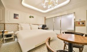 una habitación de hotel con una cama y una mesa en Daegu February Hotel DongdaeguStation, en Daegu