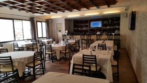 a restaurant with white tables and chairs and a bar at Hotel la Coccinelle in Bamako