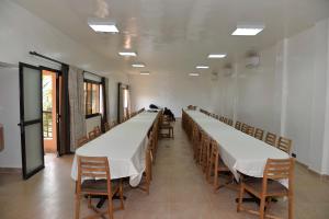 a long row of tables in a room with chairs at Hotel la Coccinelle in Bamako +52 photos