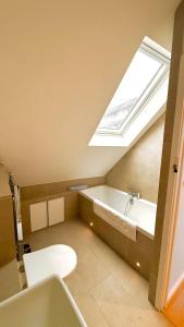 a bathroom with a bath tub and a skylight at Plum Cottage Somerset in Wells
