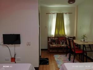 a living room with a television and a dining room table at golden anchor lodge in Coron