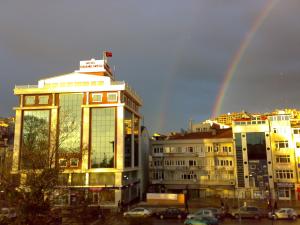 Un arcoíris en el cielo sobre una ciudad con edificios. en Hotel Grand Eregli, en Ereğli