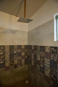 a bathroom with a tile wall with a ceiling at Artist Beach House in Morjim +43 photos