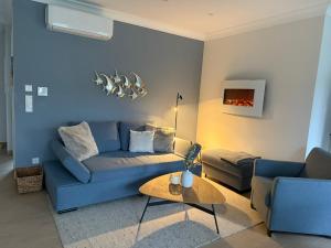 a living room with a blue couch and a table at My Baltic Sea - Ferienwohnungen im Seaside House in Scharbeutz