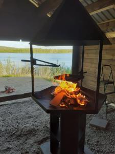 a grill with a fire inside of it at Napapiirin Eräkartano in Pello