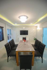 チェンマイにあるPool Villa Chiangmai View Homeのテーブルと椅子とテレビのあるリビングルーム