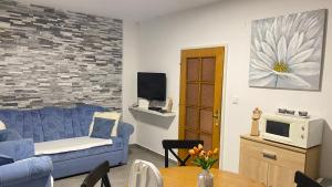 a living room with a blue couch and a tv at Apartment seafront Juraj in Tribunj