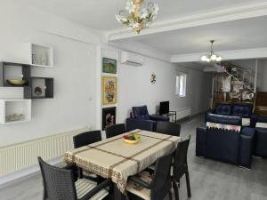 a dining room and living room with a table and chairs at Villa Taskoparan in Tekirdağ