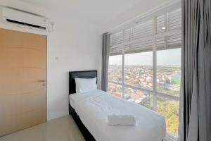 Ένα ή περισσότερα κρεβάτια σε δωμάτιο στο Spacious and Restfull 3BR at Bale Hinggil Apartment By Travelio