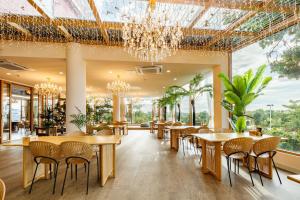 桂林市にあるGuilin Red Roof Garden Resort --Within 8000 square meter lush garden- Fluent English-Southeast Asian style decoration-Quiet and delightfulのテーブルと椅子、シャンデリアのあるレストラン