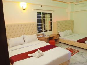 una camera d'albergo con due letti e una finestra di Hill Top Resort a Cox's Bazar Altre 2 foto