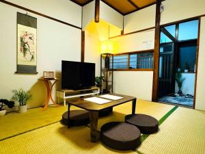 a living room with a table and a tv at 9人可能 黒門市場 けんちハウス in Osaka