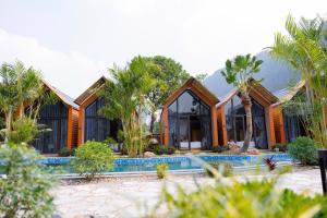 a house with a swimming pool and palm trees at Trang An Green Bungalow & Restaurant in Ninh Binh