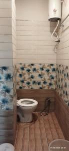 a bathroom with a toilet in a room at Gajlaxmi HOTEL UJJAIN in Ujjain