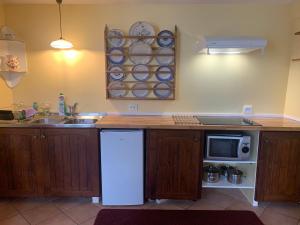 a kitchen with a white refrigerator and a microwave at Appartement près de DOLE in Menotey