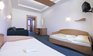 ein Hotelzimmer mit zwei Betten und einem Fernseher in der Unterkunft Penzión DRUŽBA Bojnice in Bojnice