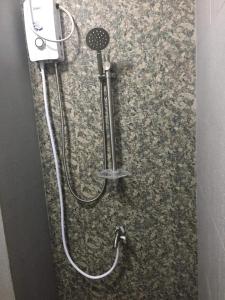 eine Dusche mit einem an der Wand befestigten Schlauch in der Unterkunft Townhouse1 Two bedrooms in Bacolor near San Fernando in Bacolor