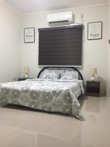 Schlafzimmer mit einem Bett mit einem Projektor an der Wand in der Unterkunft Townhouse1 Two bedrooms in Bacolor near San Fernando in Bacolor