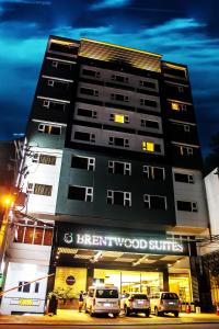 a hotel with cars parked in front of a building at Brentwood Suites in Manila