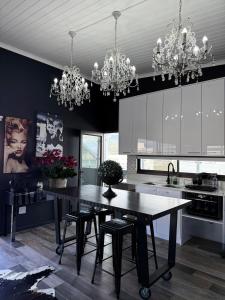 a kitchen with a dining table and chandeliers at Dior Maison de Reve- Private Penthouse in Stellenbosch