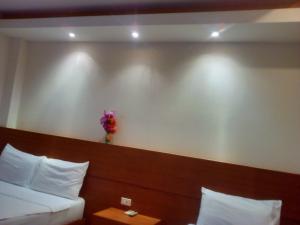 a hotel room with two beds and a vase of flowers on the wall at Modern Resort in Haad Rin