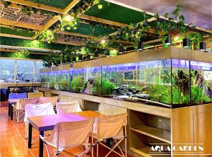a restaurant with tables and chairs and an aquarium at Misty Hills in Baguio