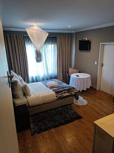 a bedroom with a bed and a table in a room at Glen Rest Country Lodge in Midrand