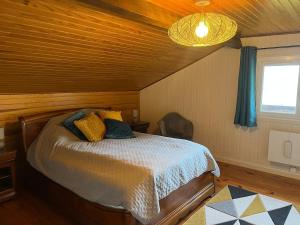 a bedroom with a bed in a wooden room at Sur les hauteurs de Labroquère in Labroquère