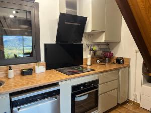 a kitchen with a counter with a television on it at Sur les hauteurs de Labroquère in Labroquère +14 photos