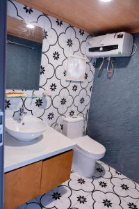 a bathroom with a white toilet and a sink at Trang An Green Bungalow & Restaurant in Ninh Binh