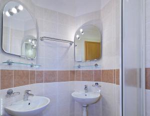 ein Badezimmer mit zwei Waschbecken und einem Spiegel in der Unterkunft Penzión DRUŽBA Bojnice in Bojnice
