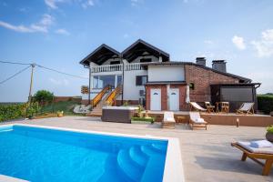 a villa with a swimming pool in front of a house at Kraljeva Kruna - kuća za odmor in Koprivnica