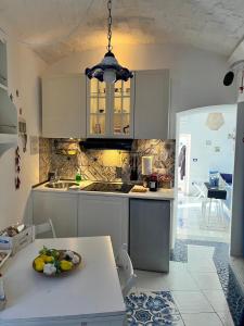 a kitchen with white cabinets and a bowl of fruit on a table at Torreammare in Salerno