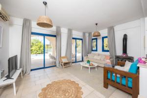 a living room with a couch and a tv at Azzurro Holiday Villas in Peyia