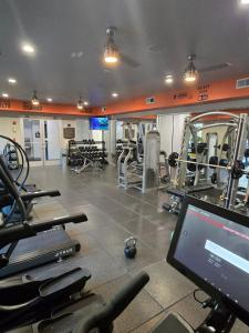 a gym with several tread machines and a computer in it at 2bdrm/2 King beds/1Air mattress in Dallas